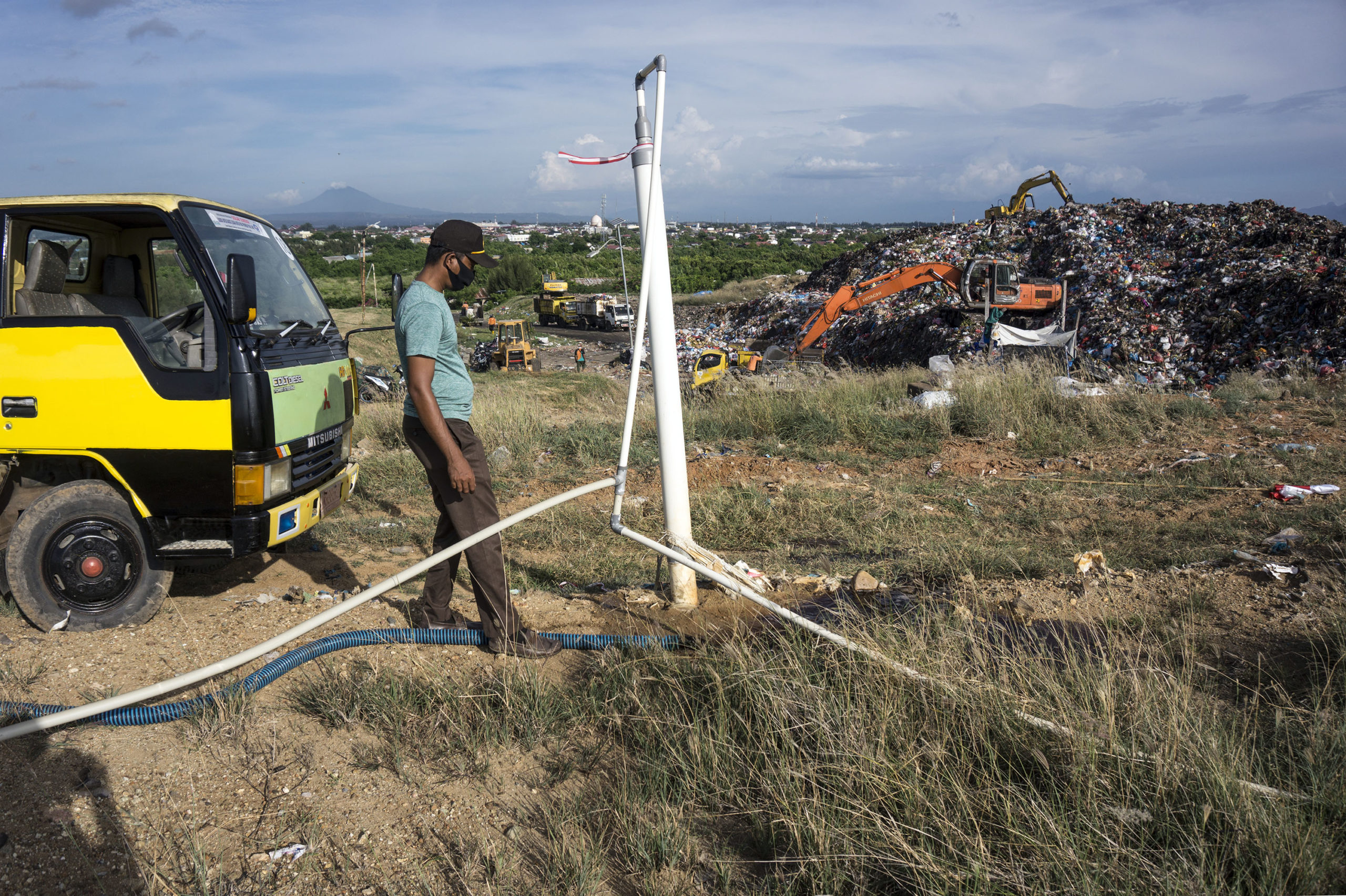 Petugas melakukan penyiraman air lindi di atas pipa penyaring biogas hasil pengolahan sampah organik di Tempat Pembuangan Akhir, Kampung Jawa, Banda Aceh, Selasa (7/9/2021).