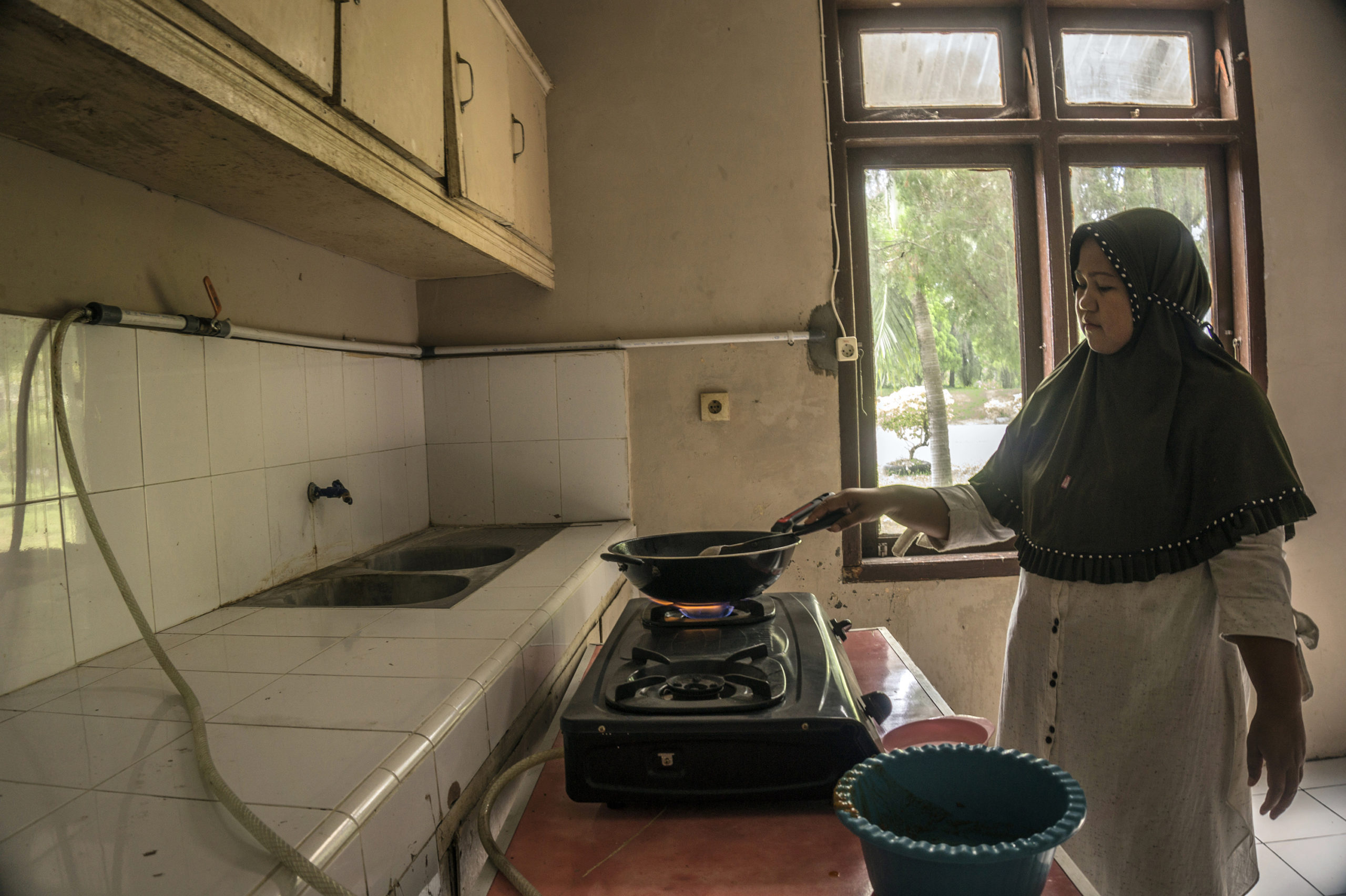 Yusnidar (35), memasak menggunakan biogas yang berasal dari pengolahan tinja manusia di komplek IPLT, Kampung Jawa, Kota Banda Aceh, Jumat (22/10/2021).