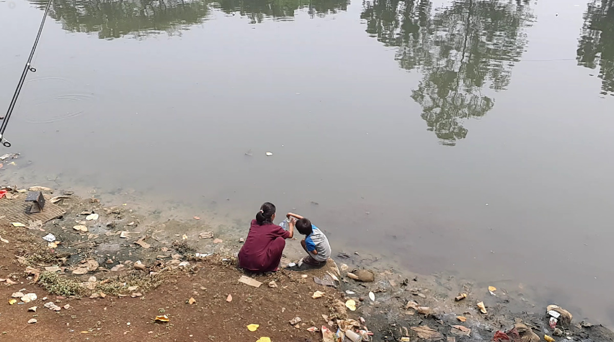 Ibu dan anak di drainase Cengkareng